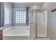 Bright bathroom featuring a soaking tub with a shower and a glass block window at 1391 E Angie St, Casa Grande, AZ 85122