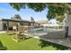 Lush backyard featuring a sparkling pool, artificial grass, and patio for outdoor enjoyment at 1508 W Kiowa Ave, Mesa, AZ 85202
