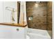 Bathroom featuring a shower-tub combo with tiled walls and a built-in niche at 1508 W Kiowa Ave, Mesa, AZ 85202
