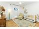 Bright Bedroom featuring a white crib, comfortable chair, and desert-themed decor at 1508 W Kiowa Ave, Mesa, AZ 85202