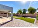 A pristine backyard features a covered patio, synthetic grass, and brick pavers at 15856 N 76Th Ave, Peoria, AZ 85382