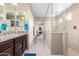 Modern bathroom with a glass-enclosed shower, granite countertops, dual sinks, and contemporary fixtures at 15856 N 76Th Ave, Peoria, AZ 85382