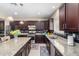 Modern kitchen with granite counters, stainless steel appliances, dark wood cabinets, and plenty of counter space at 15856 N 76Th Ave, Peoria, AZ 85382