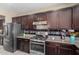 Close-up of kitchen featuring stainless steel appliances, granite counters, and dark cabinetry at 15856 N 76Th Ave, Peoria, AZ 85382