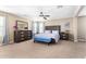 Spacious main bedroom with a ceiling fan, plush carpet, and a bench in front of the bed at 15856 N 76Th Ave, Peoria, AZ 85382