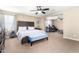 Spacious main bedroom with a bed, a blue upholstered bench, and an adjacent office space for work or study at 15856 N 76Th Ave, Peoria, AZ 85382