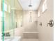 Modern walk-in shower with tiled walls, built-in bench, and multiple shower heads at 15856 N 76Th Ave, Peoria, AZ 85382