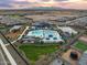 Aerial view of community amenities including a pool, splash pad, playground, and green spaces at 16076 W Prickly Pear Trl, Surprise, AZ 85387