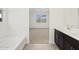 Bright bathroom showcasing tub, sink, and access to bedroom at 16076 W Prickly Pear Trl, Surprise, AZ 85387