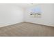 Bright, carpeted bedroom featuring a large window for natural light at 16076 W Prickly Pear Trl, Surprise, AZ 85387