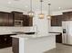 Modern kitchen with stainless steel appliances, dark wood cabinets, and a spacious island at 16076 W Prickly Pear Trl, Surprise, AZ 85387