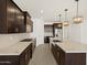 Spacious kitchen with stainless steel appliances, a large island, dark wood cabinets and white countertops at 16076 W Prickly Pear Trl, Surprise, AZ 85387