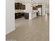 Modern kitchen with dark cabinets, stainless steel appliances, a center island, and wood-look tile flooring at 16076 W Prickly Pear Trl, Surprise, AZ 85387