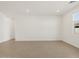 Bright, empty living room with wood-look tile flooring and a window offering natural light at 16076 W Prickly Pear Trl, Surprise, AZ 85387