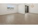 Open floor plan featuring wood-look tile flooring, large windows, and a modern light fixture at 16076 W Prickly Pear Trl, Surprise, AZ 85387
