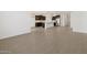 Open floor plan featuring wood-look tile flooring, a kitchen with an island, and white walls at 16076 W Prickly Pear Trl, Surprise, AZ 85387