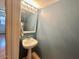 Cozy powder room with a pedestal sink, decorative mirror, and a neutral color palette at 1706 W Village Way, Tempe, AZ 85282