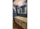 Bathroom featuring granite countertop vanity, decorative mirrors, and blue walls exudes style and functionality at 1706 W Village Way, Tempe, AZ 85282