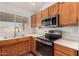 Well-lit kitchen featuring stainless steel appliances, wooden cabinetry and a double sink at 1716 N Temple St, Mesa, AZ 85203