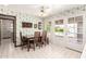 Dining area featuring white tiled floors, a glass table, and seamless access to the patio at 1934 E Hale St, Mesa, AZ 85203