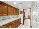 Long kitchen counter with wood cabinets and view to hallway at 1934 E Hale St, Mesa, AZ 85203