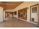 Charming covered patio, featuring a ceiling fan, tiled floors, and direct backyard access through wooden doors at 1934 E Hale St, Mesa, AZ 85203