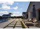 Backyard with modern lounge chairs, umbrellas, and turf lined pavers at 19901 E Country Meadows Dr, Queen Creek, AZ 85142