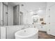 Bright bathroom with an oval soaking tub, walk-in shower, stylish cabinets, and herringbone wood floor at 19901 E Country Meadows Dr, Queen Creek, AZ 85142