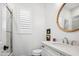 Clean, bright bathroom featuring a stylish vanity, round mirror, and a walk-in shower with glass doors at 19901 E Country Meadows Dr, Queen Creek, AZ 85142