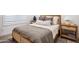 Cozy bedroom with a wooden bed frame, neutral bedding, bedside tables, and soft carpeting at 19901 E Country Meadows Dr, Queen Creek, AZ 85142