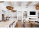 Open-concept kitchen with a large island, seamlessly connected to the living area with a cozy fireplace at 19901 E Country Meadows Dr, Queen Creek, AZ 85142