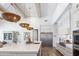Bright kitchen featuring white cabinets, stainless steel appliances, a large island, and wood floors at 19901 E Country Meadows Dr, Queen Creek, AZ 85142