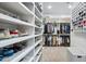 Expansive walk-in closet with floor-to-ceiling shelves and rods for ample clothing and shoe storage at 19901 E Country Meadows Dr, Queen Creek, AZ 85142