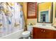 Bathroom with cherry cabinets, white countertop, louvered window, and a shower with a butterfly curtain at 21557 N Anne Ln, Maricopa, AZ 85138