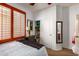 Bright bedroom with a large window, plantation shutters, a comfortable bed, and closet access at 21557 N Anne Ln, Maricopa, AZ 85138