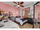 Comfortable bedroom with a ceiling fan, a large window, and a spacious desk for work or study at 21557 N Anne Ln, Maricopa, AZ 85138