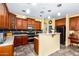 Kitchen featuring dark cabinets, stainless appliances, tile floors, stylish lighting and eat-in bar at 21557 N Anne Ln, Maricopa, AZ 85138