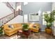Inviting living room boasts a cozy yellow sectional, a decorative coffee table, and a staircase at 21557 N Anne Ln, Maricopa, AZ 85138