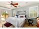 Well-lit main bedroom with balcony access, ceiling fan, and comfortable seating at 21557 N Anne Ln, Maricopa, AZ 85138