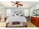 Bright main bedroom features a ceiling fan, shutters, and access to a private balcony at 21557 N Anne Ln, Maricopa, AZ 85138