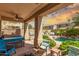 Covered patio with seating, a barbecue, string lights, and a view of the pool at 21557 N Anne Ln, Maricopa, AZ 85138