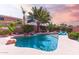 Sparkling pool with a rock waterfall, surrounded by lush greenery and cozy lounge chairs at 21557 N Anne Ln, Maricopa, AZ 85138