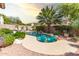 A private backyard pool oasis surrounded by vibrant greenery, a patio and comfortable seating at 21557 N Anne Ln, Maricopa, AZ 85138