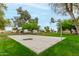 An outdoor basketball court in a grassy park setting with mature trees and residential homes nearby at 2319 E San Tan Dr, Gilbert, AZ 85296