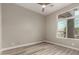 Bedroom with wood-look floors, a ceiling fan, and large window overlooking the exterior at 2319 E San Tan Dr, Gilbert, AZ 85296