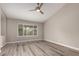 Bright bedroom featuring wood-look floors, a ceiling fan, and a large window at 2319 E San Tan Dr, Gilbert, AZ 85296