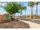 Street view of the community entrance with sign, landscaping, and palm trees on a sunny day at 2319 E San Tan Dr, Gilbert, AZ 85296