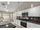 Bright kitchen featuring stainless steel appliances, granite countertops, and white cabinets at 2319 E San Tan Dr, Gilbert, AZ 85296
