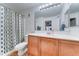 Bright bathroom featuring a single sink vanity with storage and a shower with patterned curtain at 2402 E 5Th St # 1532, Tempe, AZ 85288
