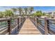 Scenic wooden bridge over a pond, surrounded by lush palm trees and community gathering spaces at 2658 S Sulley Dr # 102, Gilbert, AZ 85295
